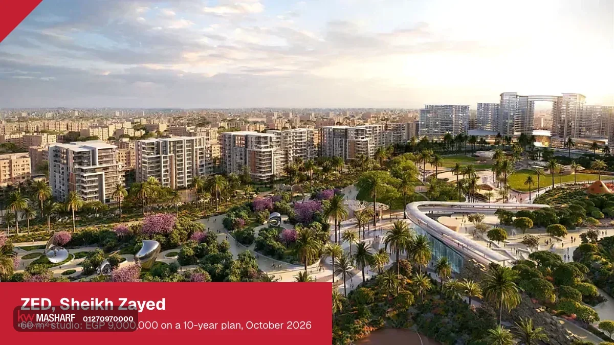 Wide view of residential towers beyond a large landscaped park with a curving footbridge