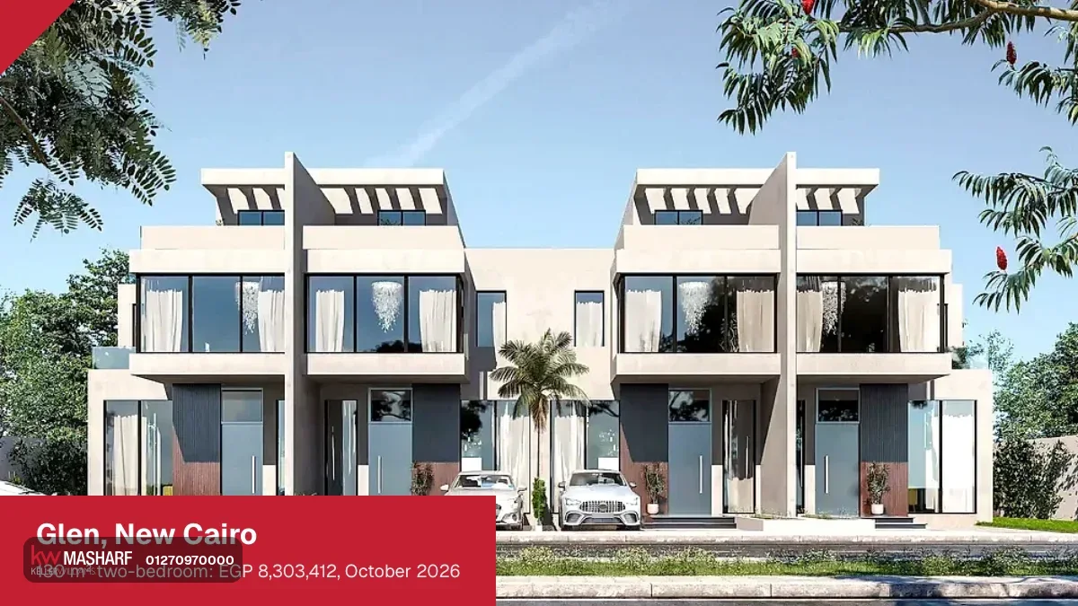 Pair of modern white townhouses with dark window frames and cars parked in front